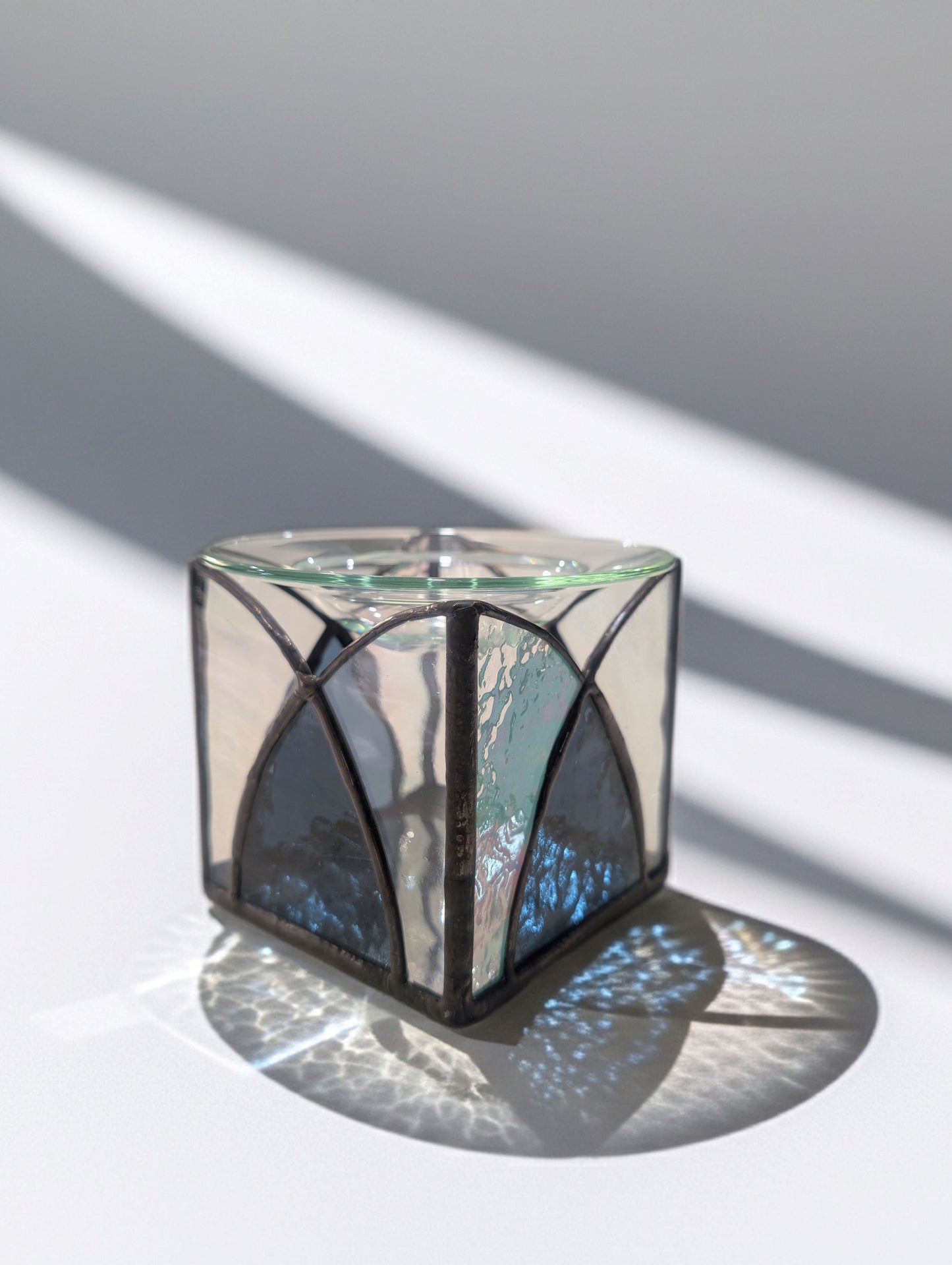 Decorative glass cube with geometric design on a light background