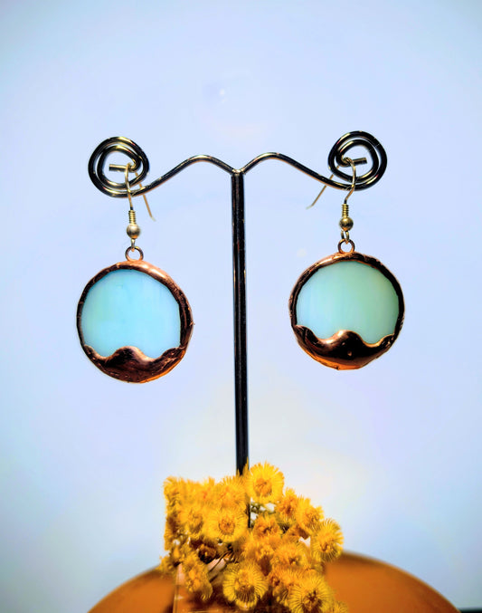 Pair of earrings on a stand with a blurred background