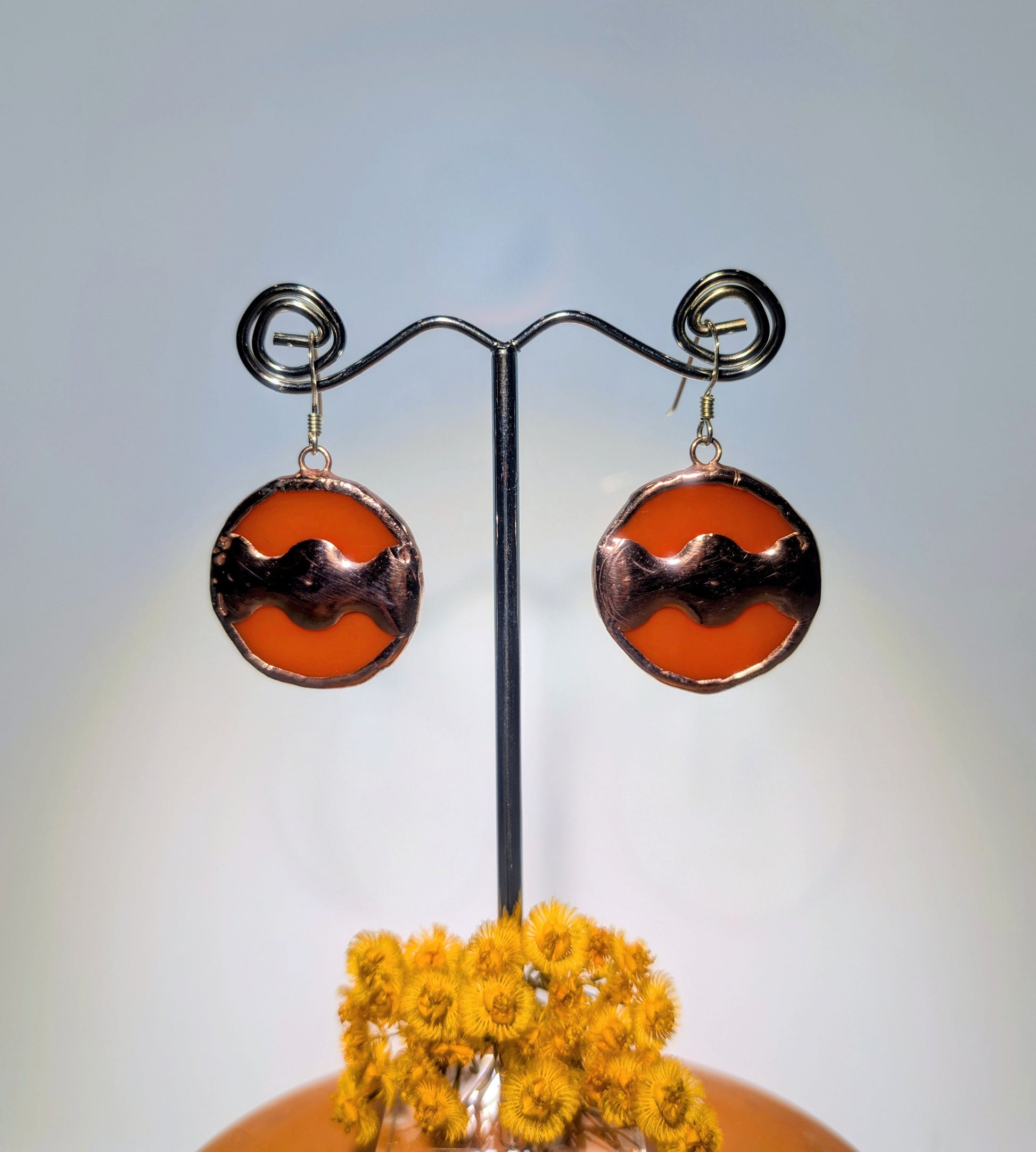 Round earrings on a stand with a blurred background