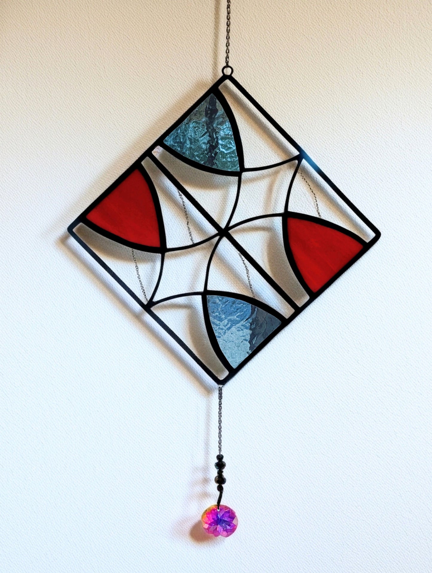 Stained glass suncatcher with geometric design on a white background