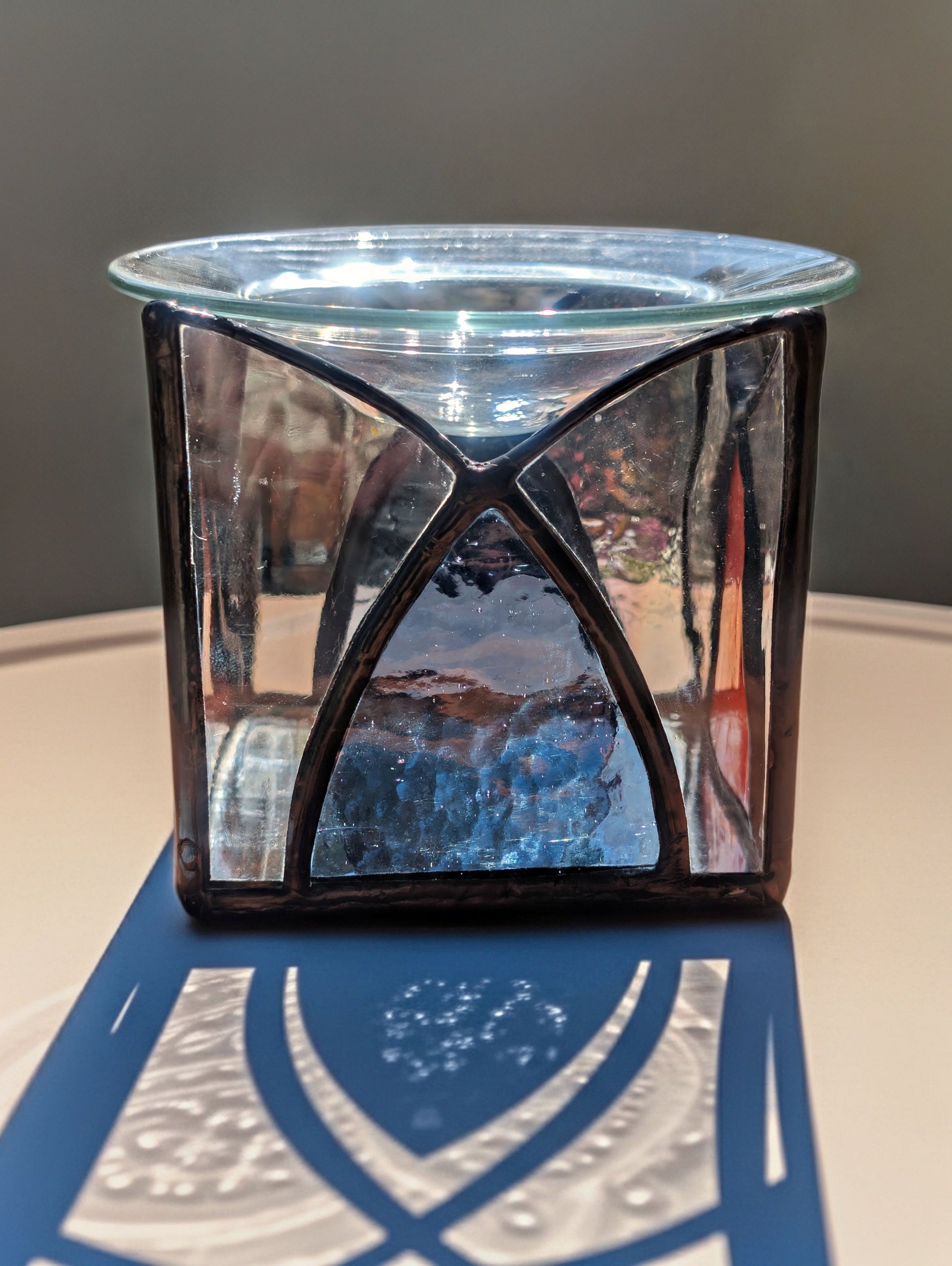Decorative glass candle holder with geometric design on a neutral background