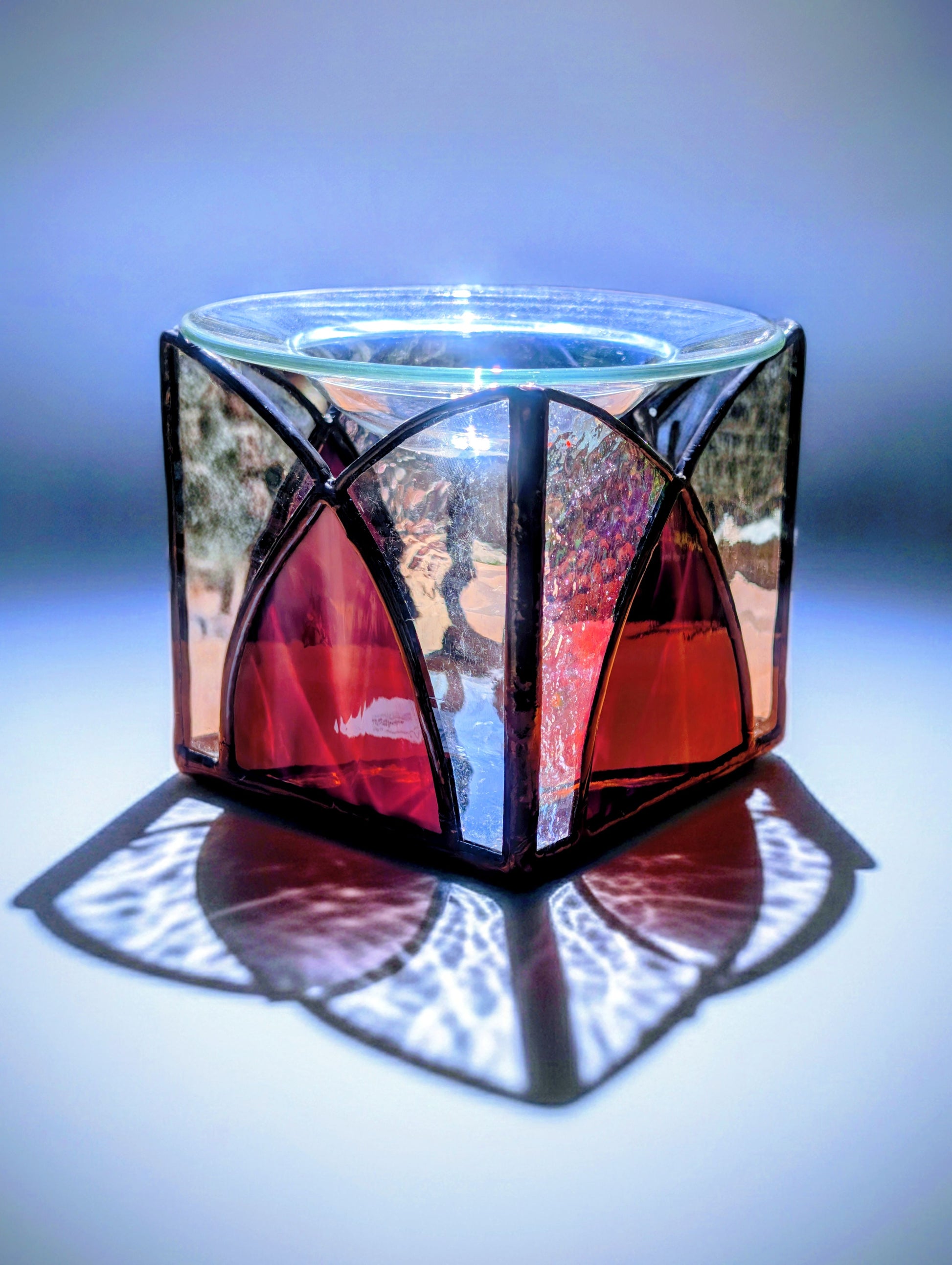 Fused glass candle holder with geometric design on a white background