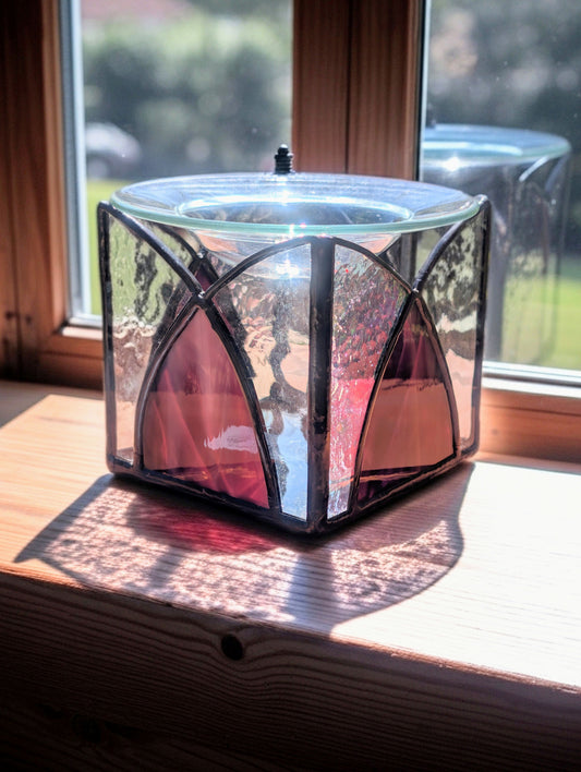 Decorative glass lantern on a windowsill with sunlight casting shadows
